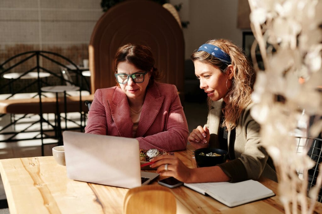 2 women working studying watching computer